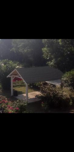 a pavilion with a black roof in a park at Apartmani Romansa Perucac in Perućac