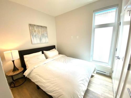 ein Schlafzimmer mit einem weißen Bett und einem Fenster in der Unterkunft Lovely Brand New Suite in Sidney
