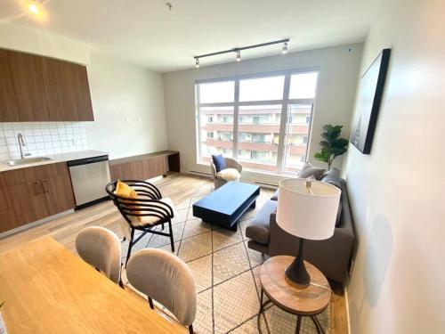 a living room with a table and chairs and a kitchen at Lovely Brand New Suite in Sidney