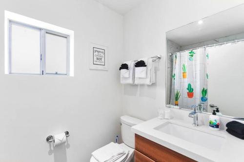 a white bathroom with a sink and a mirror at DTPH Mid Century Studio w/Pool & Parking in Phoenix