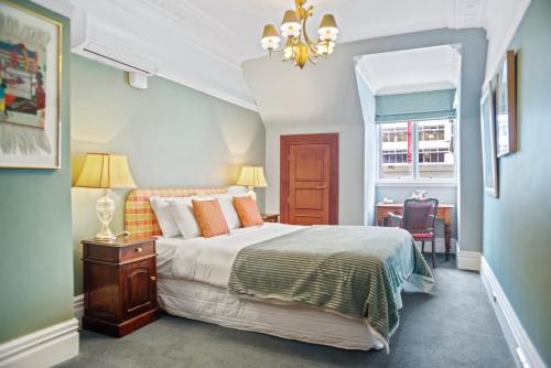 a bedroom with a bed and a chandelier at Wellesley Boutique Hotel in Wellington