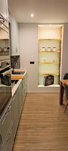 a kitchen with gray cabinets and a wooden floor at Faro Comfy Ensuite Guest House in Faro