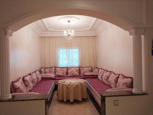 a living room with a large couch and a table at Appartement Martil , très proche de la plage in Martil