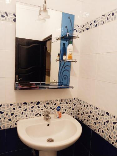 a bathroom with a sink and a mirror at Appartement Martil , très proche de la plage in Martil