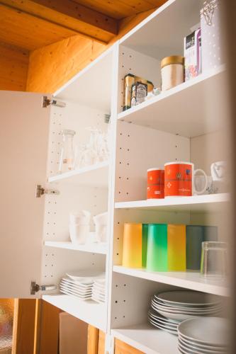 a kitchen pantry with plates and bowls on shelves at Naturnahes Familienchalet mit Garten - Wifi - Netflix - nur 15 Minuten vom Chiemsee und 35 Minuten von München entfernt in Vogtareuth