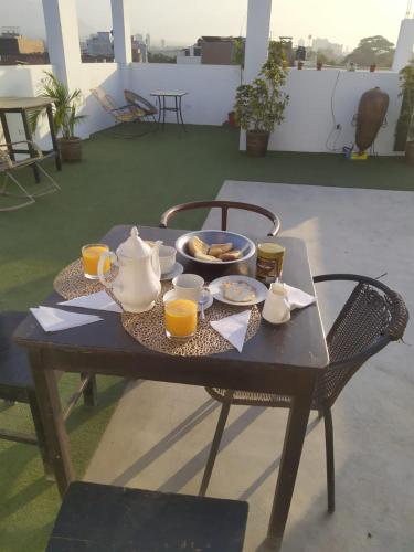 a table with a tray of food and pitchers of orange juice at Ambigua Hospedaje in Trujillo
