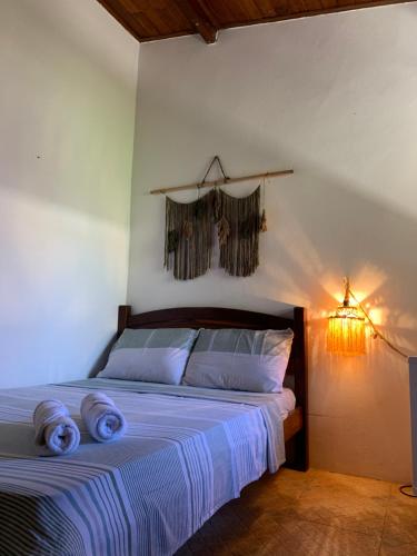Un dormitorio con una cama con toallas azules. en Pousada Recanto das Estrelas, en Morro de São Paulo