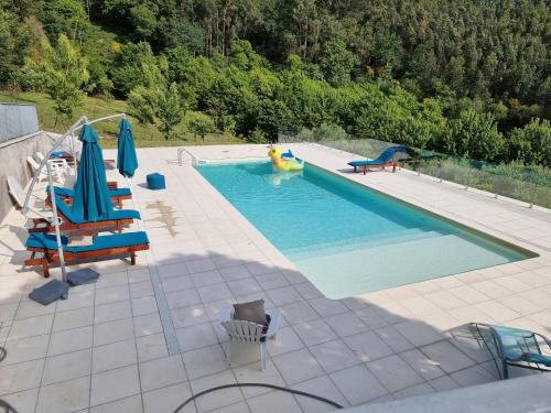 a swimming pool with chairs and a raft in a pool at Casa de Férias V6 com piscina in Ponte de Lima
