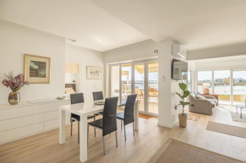 una cucina e una sala da pranzo con tavolo e sedie di OceanFront & Big Terrace Private Condo a Oeiras