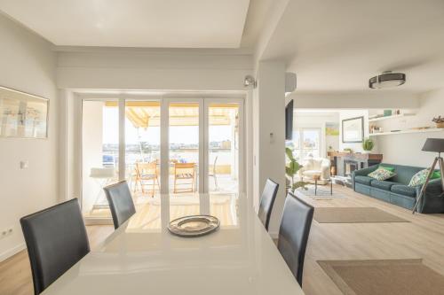 a dining room and living room with a table and chairs at OceanFront & Big Terrace Private Condo in Oeiras