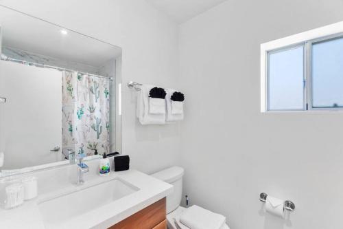 a white bathroom with a sink and a window at Walkable DTPH Studio w/ Pool and Parking in Phoenix
