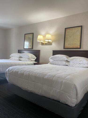 um quarto de hotel com duas camas com almofadas brancas em Osage Village Inn em Osage Beach