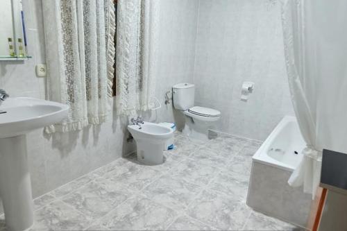 Baño blanco con aseo y lavamanos en Agradable casa con zona de relax y aparcamiento, en San Clemente