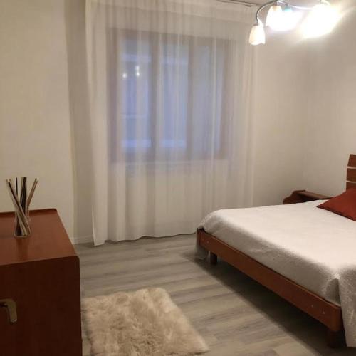 a white bedroom with a bed and a window at Casa Mattei in Chioggia