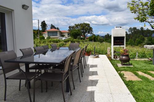 a black table and chairs sitting on a patio at Casa dos Picoutos AL in Monção