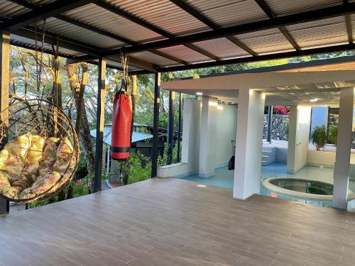 a house with a large porch with a swing at Pacific Kalokairi - Adults Only in Tamarindo