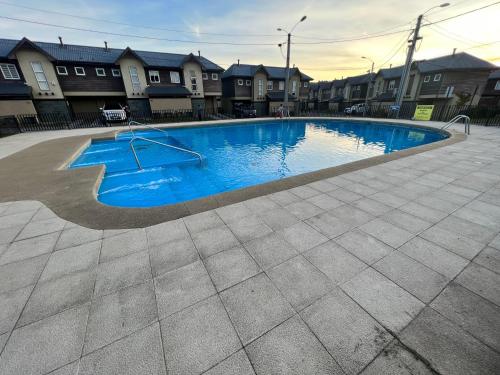 a large swimming pool in a yard with houses at Casa nueva en Pucón in Pucón