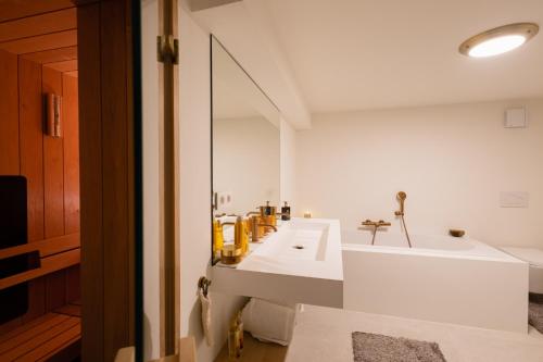 ein weißes Badezimmer mit einem Waschbecken und einem Spiegel in der Unterkunft Chez Blanche in Waterloo