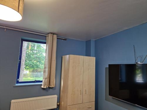 a room with a tv and a cabinet and a window at Chique Maidstone Studio II in Kent