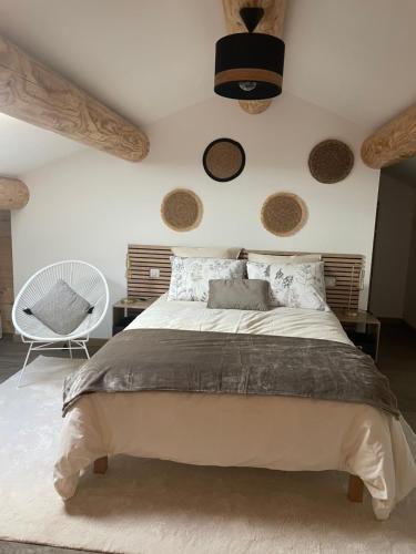 a bedroom with a large bed and a chair at Mazet Le Micocoulier in Saint-Rémy-de-Provence