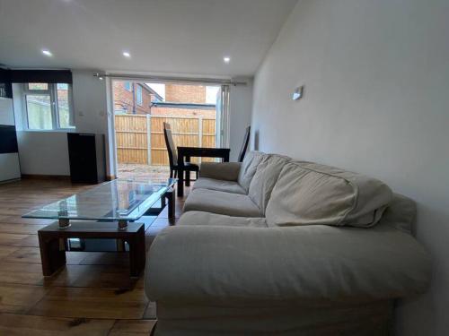 a living room with a couch and a glass table at Detached cheviot house in London