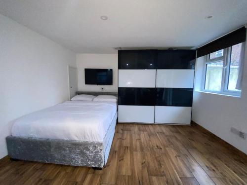 a bedroom with a bed and a television in it at Detached cheviot house in London