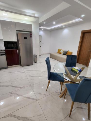 uma sala de estar com um sofá, uma mesa e cadeiras em MARINA APPART Hôtel em Dakar