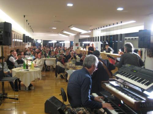 a group of people sitting in a room with a piano at Schio Hotel in Schio