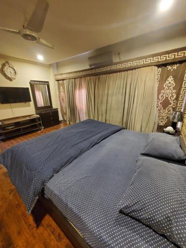 a bedroom with a large bed and a television at CosmoStay Islamabad, Bahria Town in Rawalpindi
