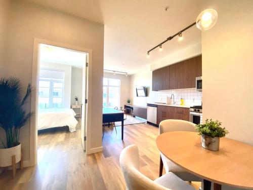 a kitchen and a living room with a table and a bed at Lovely Brand New Condo in Sidney