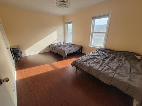 a bedroom with a bed and a window and a table at 4 Bedroom 3 bathroom 6 queen bed 5 full floor mattress with backyard Whole house for travel or vacation public and celebration group gatherings in Toronto