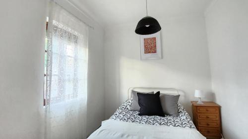 um quarto branco com uma cama e uma janela em Casa Castanheiro em Tolosa