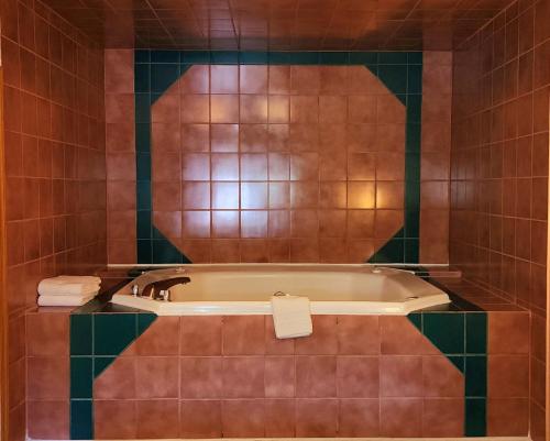 La salle de bains est pourvue d'une baignoire et de carrelage vert. dans l'établissement Silver Saddle Motel, à Manitou Springs