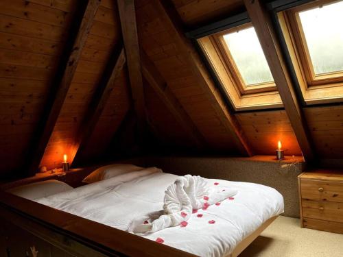 a bed in a attic with two windows and two candles at Romantische Oase mit Kamin in Unterseen