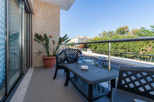 a patio with a table and chairs on a balcony at Apartamento Mãe Soberana in Loulé