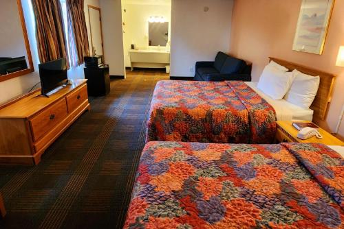 a hotel room with two beds and a television at Silver Saddle Motel in Manitou Springs