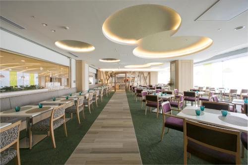 una sala da pranzo con tavoli e sedie di Hotel Granvia Hiroshima a Hiroshima