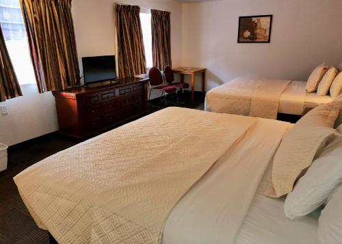 a hotel room with two beds and a desk at Silver Saddle Motel in Manitou Springs