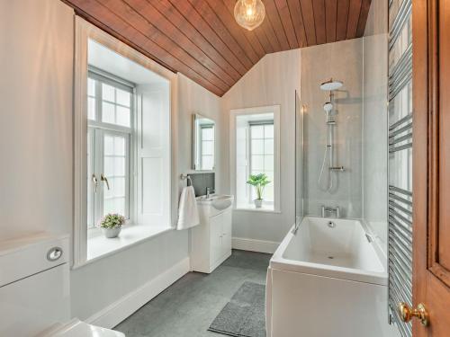 a bathroom with a tub and a sink at Groudd Hall in Cerrigydrudion