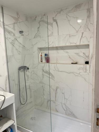 La salle de bains est pourvue d'une douche en marbre blanc. dans l'établissement Zena Houses, à Beja