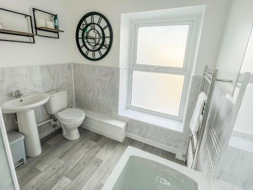 a bathroom with a sink toilet and a window at Bwthyn Cerrigos in Milford Haven