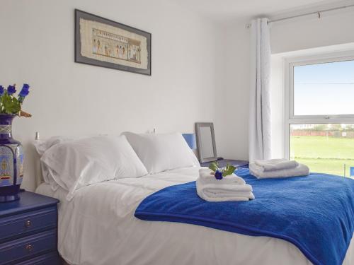a bedroom with a bed with towels on it at Bwthyn Cerrigos in Milford Haven