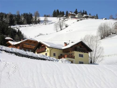 a house on a snow covered hill with snow at Wirnsberg in Aschbach