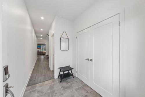 a hallway with white cabinets and a black stool at Jewel of Blue Mountain - Walk to Ski and Village - EV plug in Blue Mountains