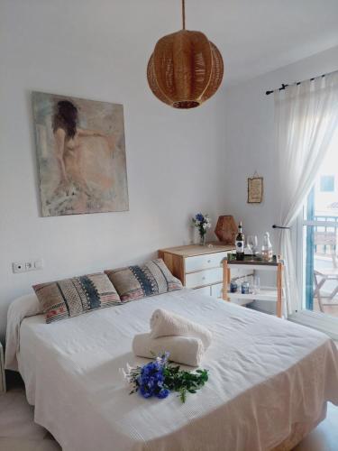 a white bedroom with a large bed with flowers on it at A Mar in El Rompido