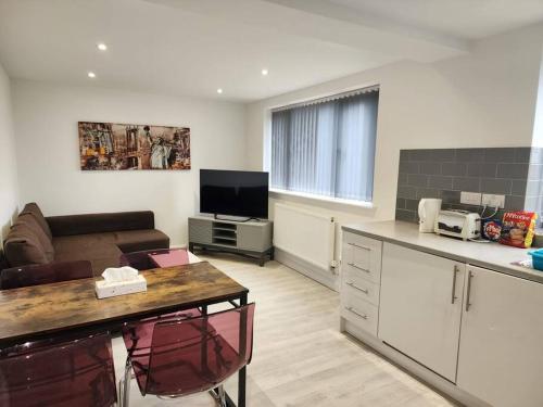 a kitchen and living room with a couch and a table at Hazel 1-Bed Flat (4) + Parking in Kidlington