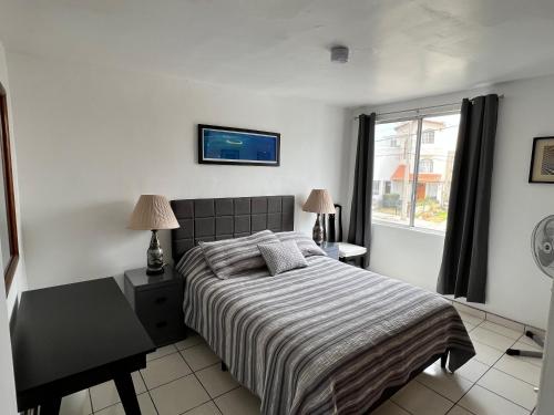 Schlafzimmer mit einem Bett und einem Fenster in der Unterkunft Casa Mediterraneo in Ensenada
