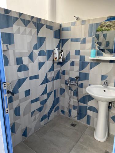 a blue and white bathroom with a sink and a toilet at Mpasales house in Skiros