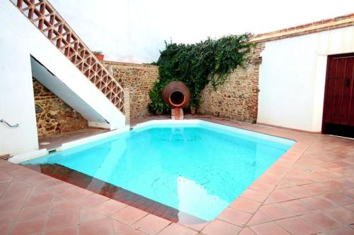 een zwembad op een binnenplaats met een trap bij Alojamiento rural la fábrica de palos in Cazalla de la Sierra