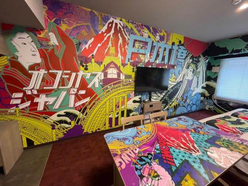 a bedroom with a colorful mural on the wall at MONday Apart Nihonbashi Ningyocho in Tokyo